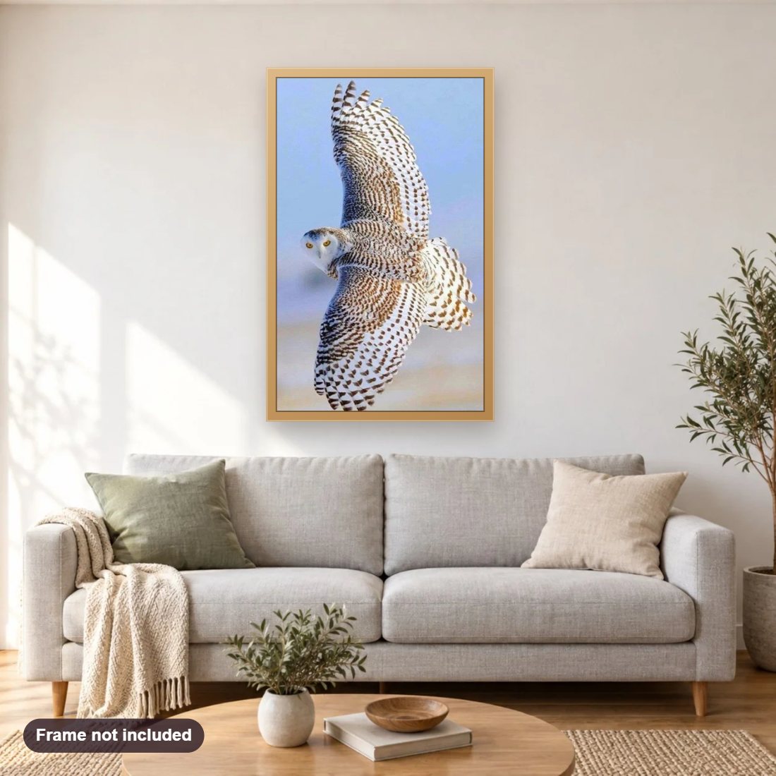 Beautiful Flying Snow Owl diamond painting shown framed on a living room wall above a sofa