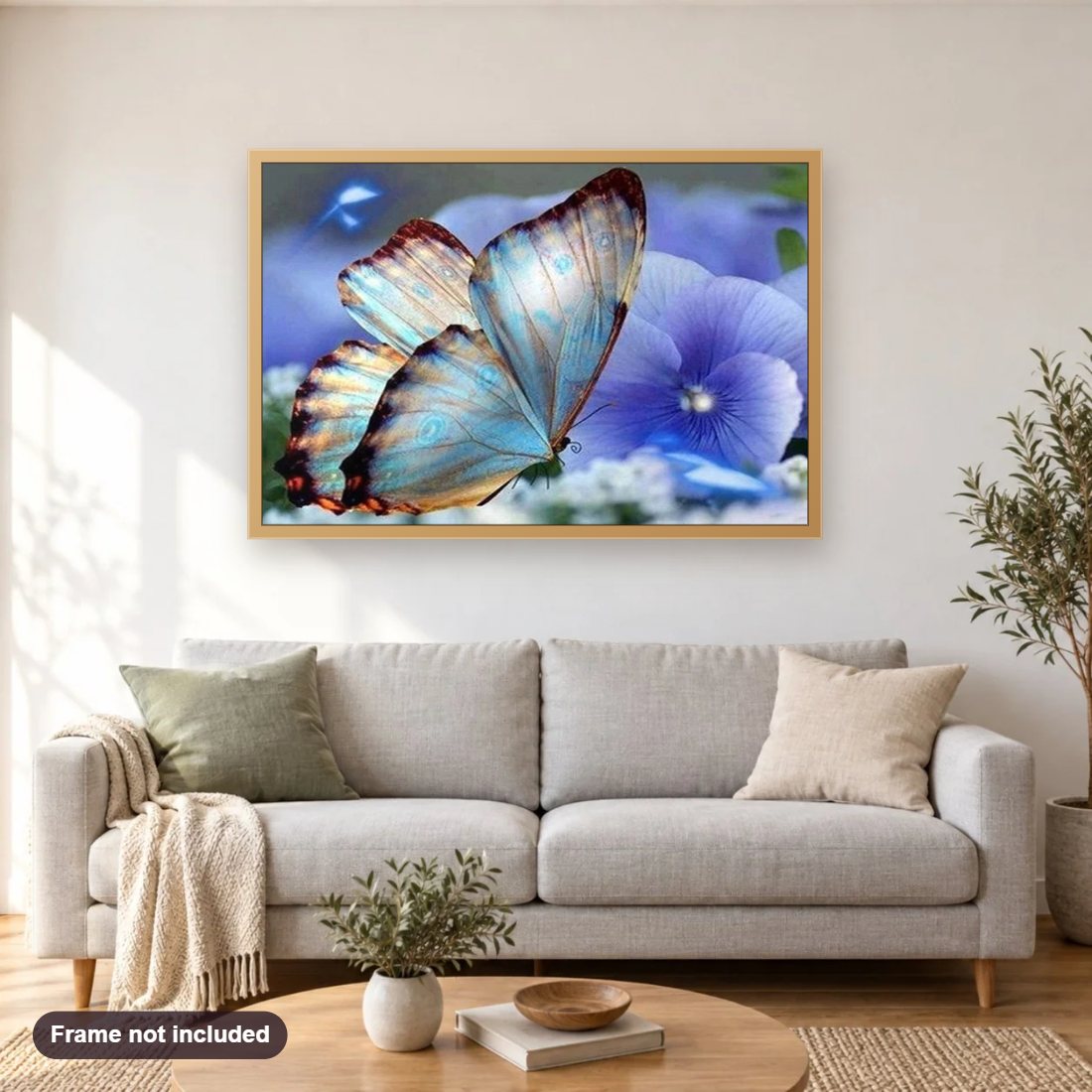 Blue Orchids & Butterfly diamond painting shown framed on a living room wall above a sofa