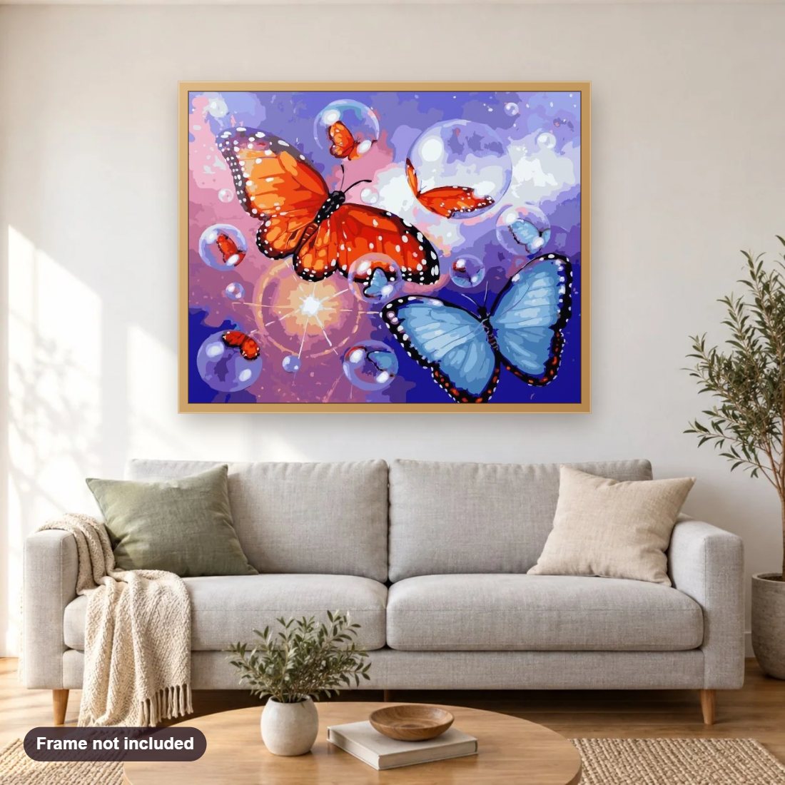 Bubbles & Butterflies diamond painting shown framed on a living room wall above a sofa