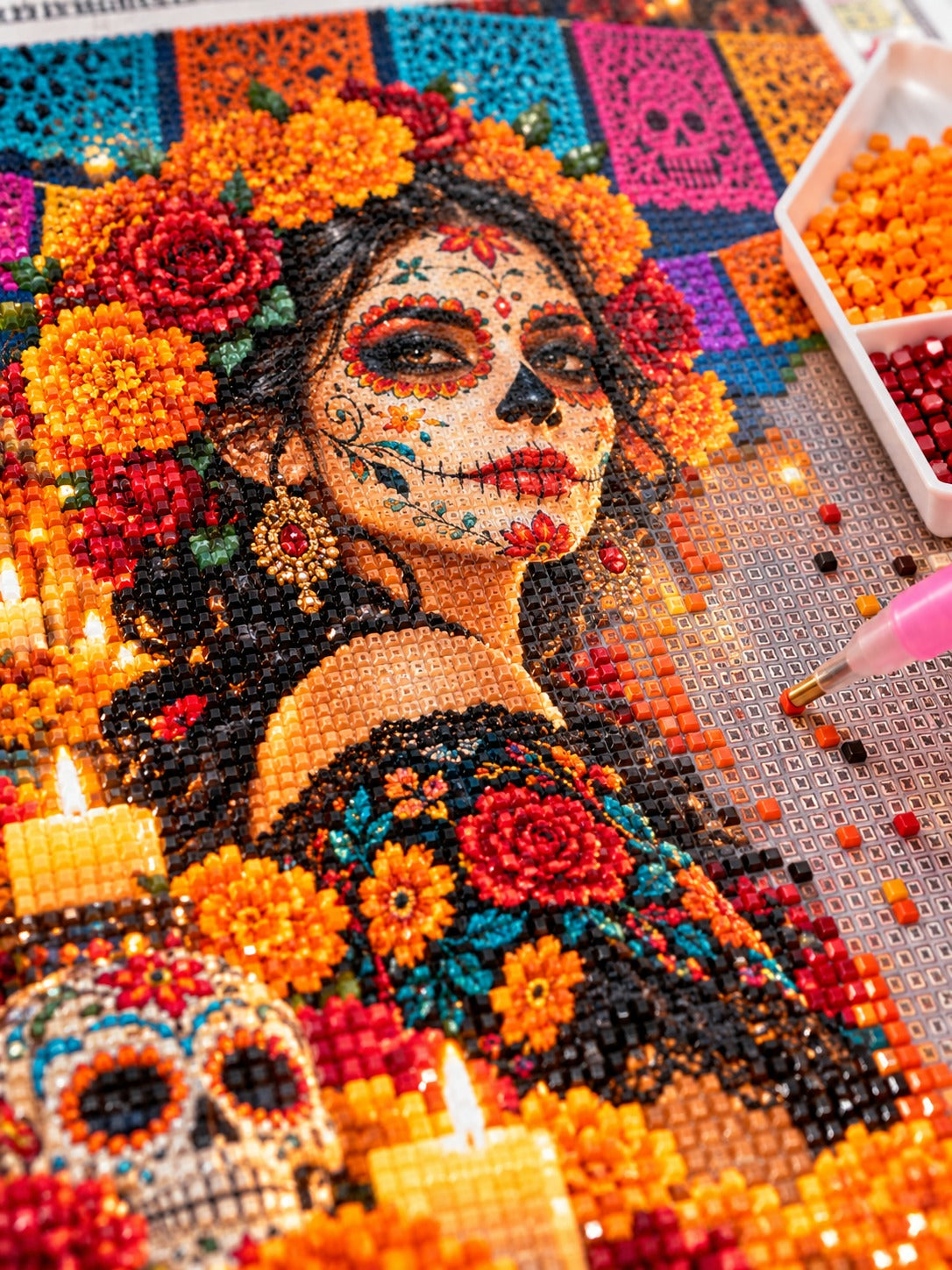 Close-up of the Day of the Dead calavera queen with marigolds and roses diamond painting in progress, square resin drills, wax pen and drill tray