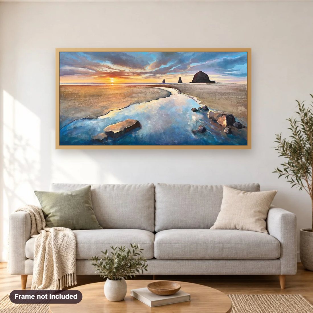 Cannon Beach Sunset diamond painting shown framed on a living room wall above a sofa