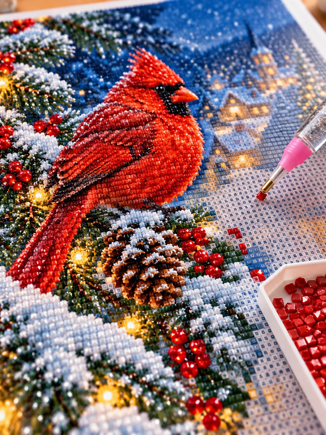 Close-up of the red cardinal on a snowy pine branch at twilight diamond painting in progress, square resin drills, wax pen and drill tray