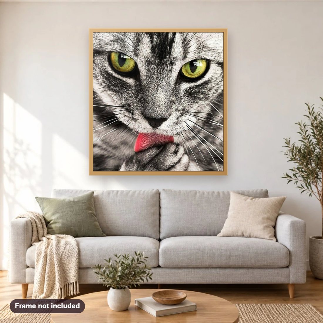 Cat Licking Paw diamond painting shown framed on a living room wall above a sofa