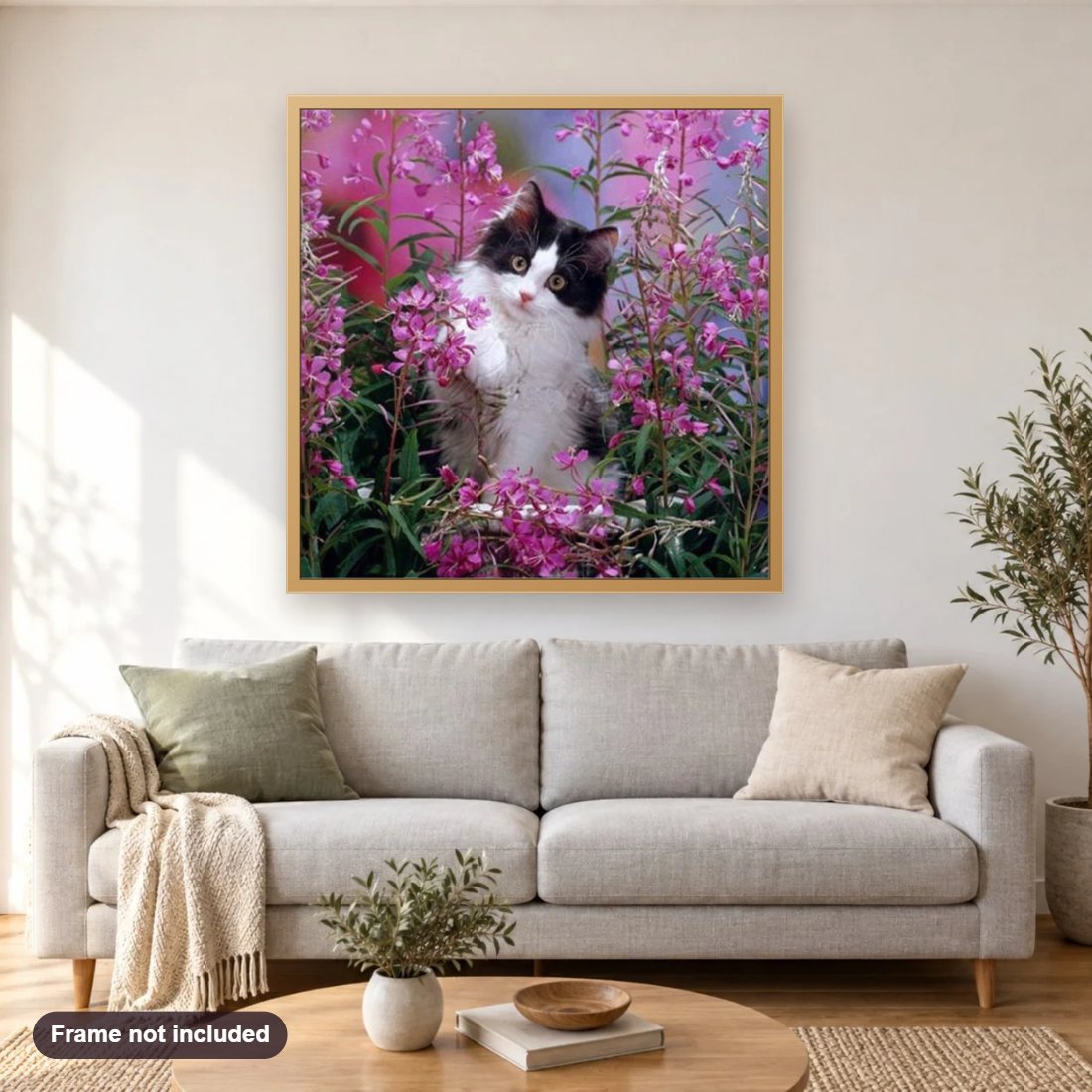 Cat Playing in Flowers diamond painting shown framed on a living room wall above a sofa