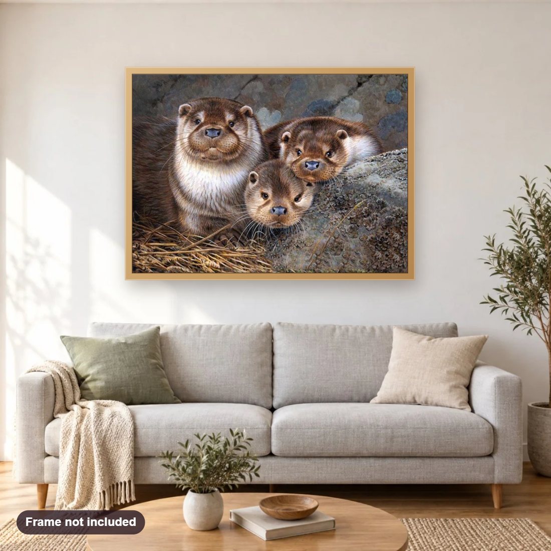 Cute Otter Babies diamond painting shown framed on a living room wall above a sofa