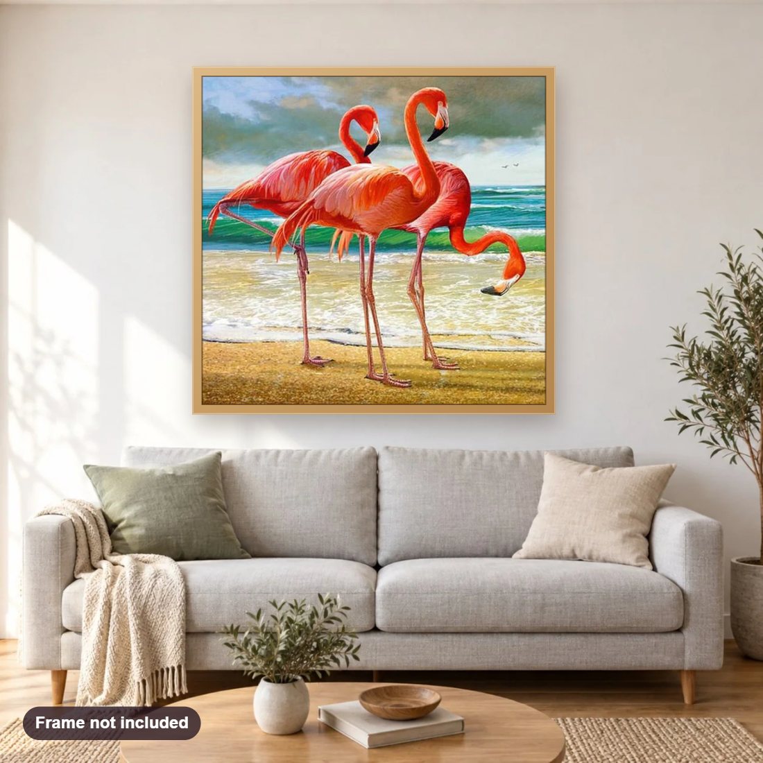 Flamingos on the Beach diamond painting shown framed on a living room wall above a sofa