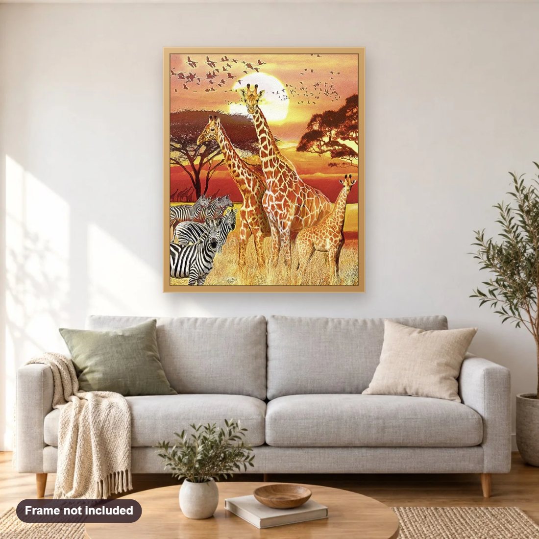 Giraffes & Zebras diamond painting shown framed on a living room wall above a sofa