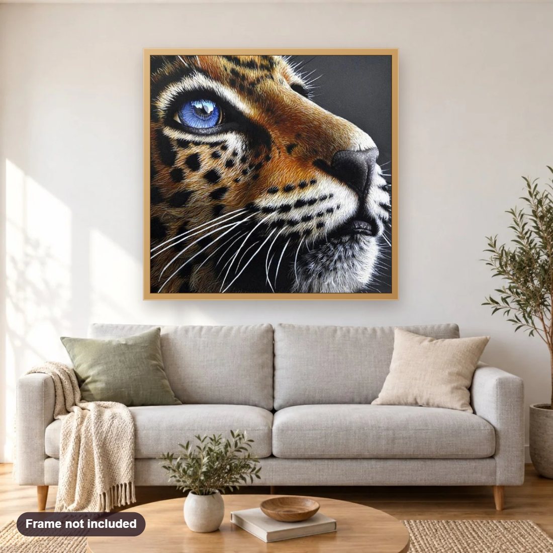 Jaguar Cub with Blue Eyes diamond painting shown framed on a living room wall above a sofa