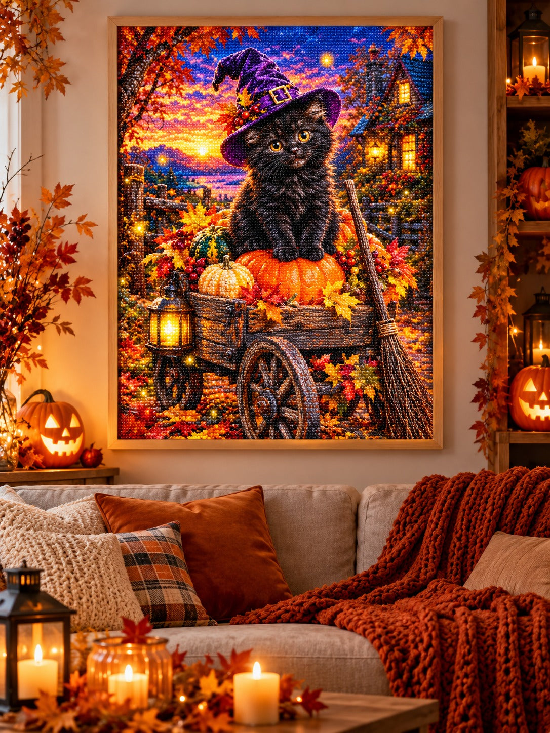 Finished black kitten in a witch hat on a pumpkin cart diamond painting in a light oak frame hanging in a cozy living room decorated for autumn and Halloween