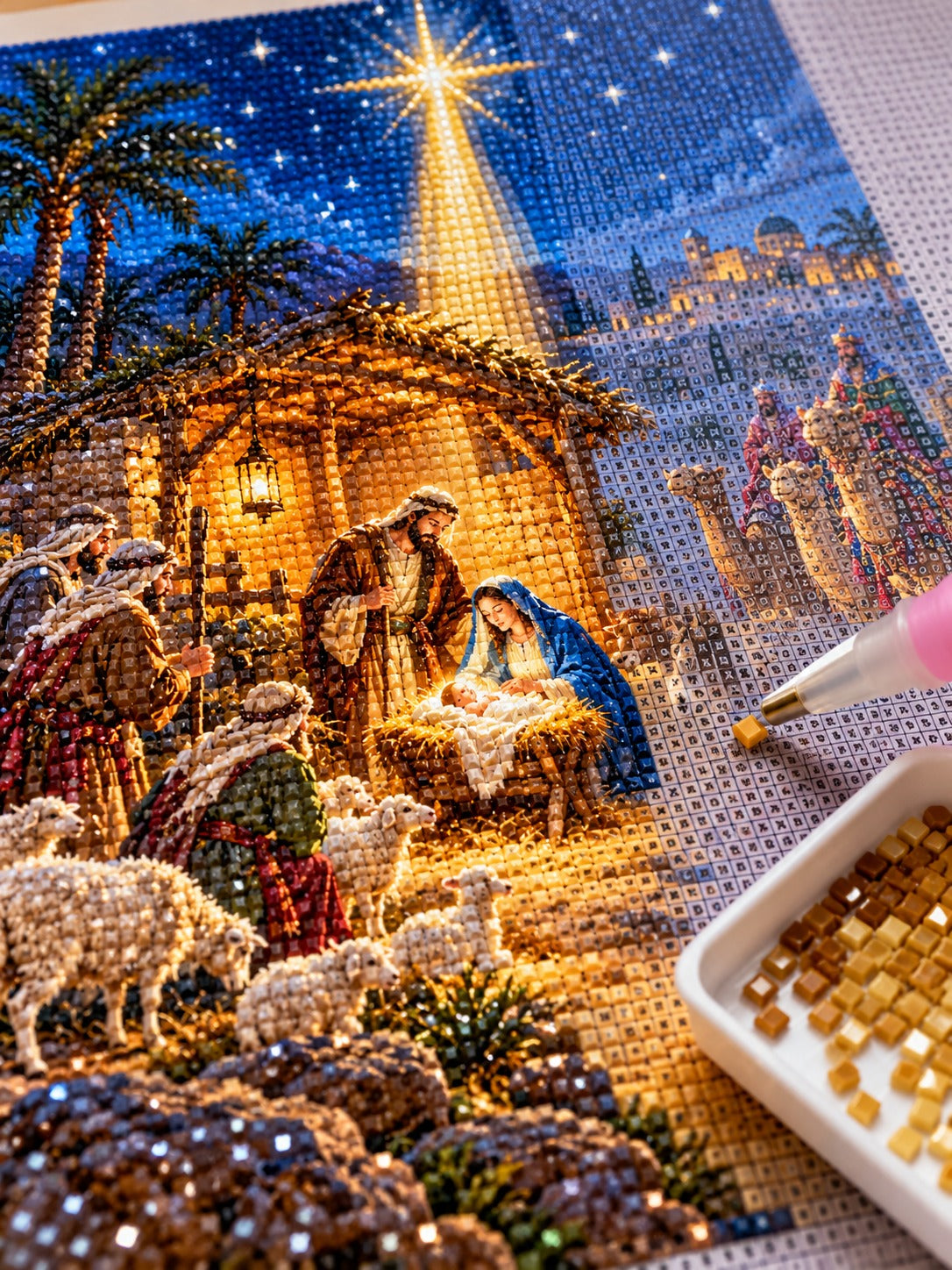 Close-up of the Nativity stable under the Star of Bethlehem diamond painting in progress, square resin drills, wax pen and drill tray