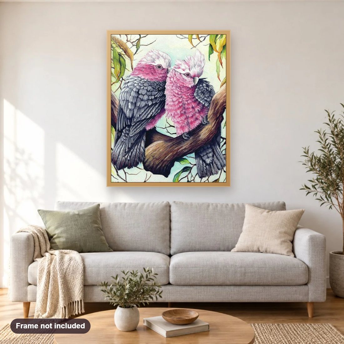 Pink & Grey Cockatoos Pair diamond painting shown framed on a living room wall above a sofa