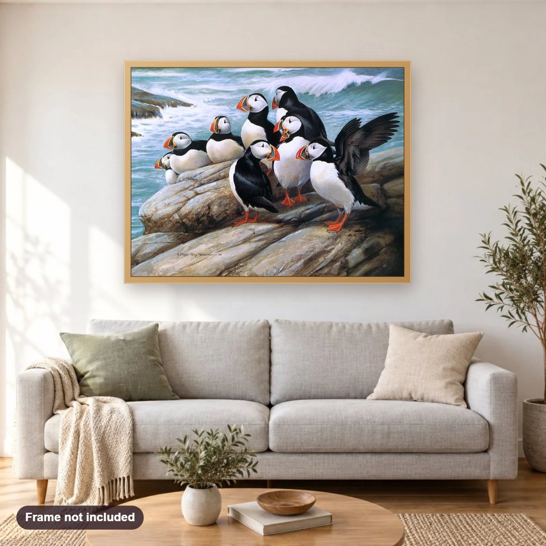 Puffins diamond painting shown framed on a living room wall above a sofa