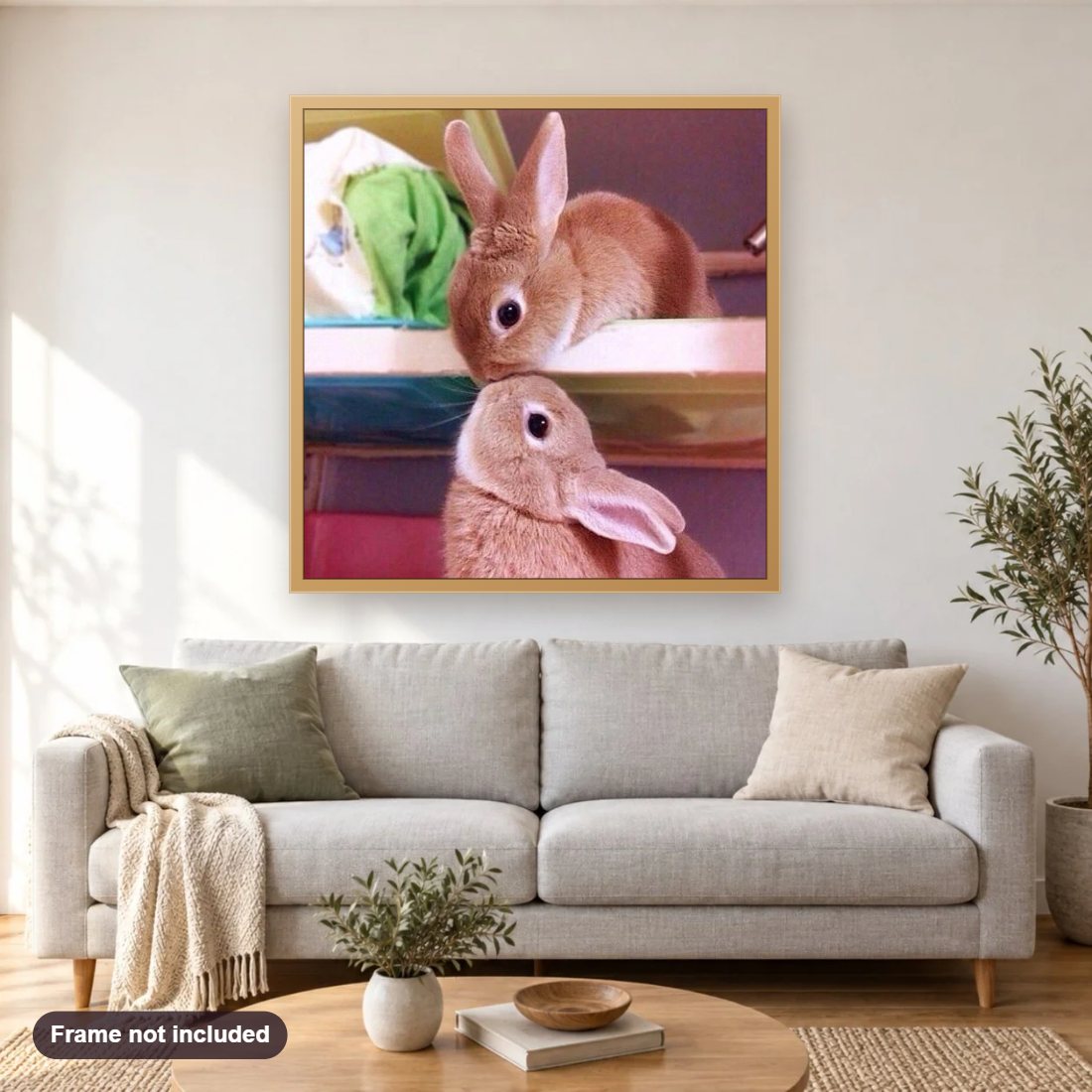 Rabbits Kissing diamond painting shown framed on a living room wall above a sofa