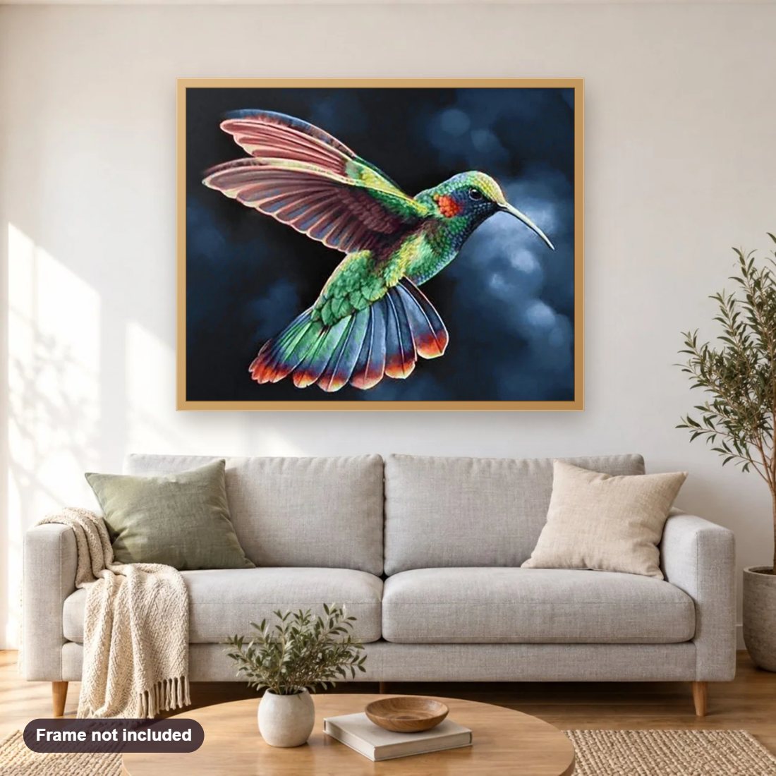 Rainbow Humming Bird diamond painting shown framed on a living room wall above a sofa