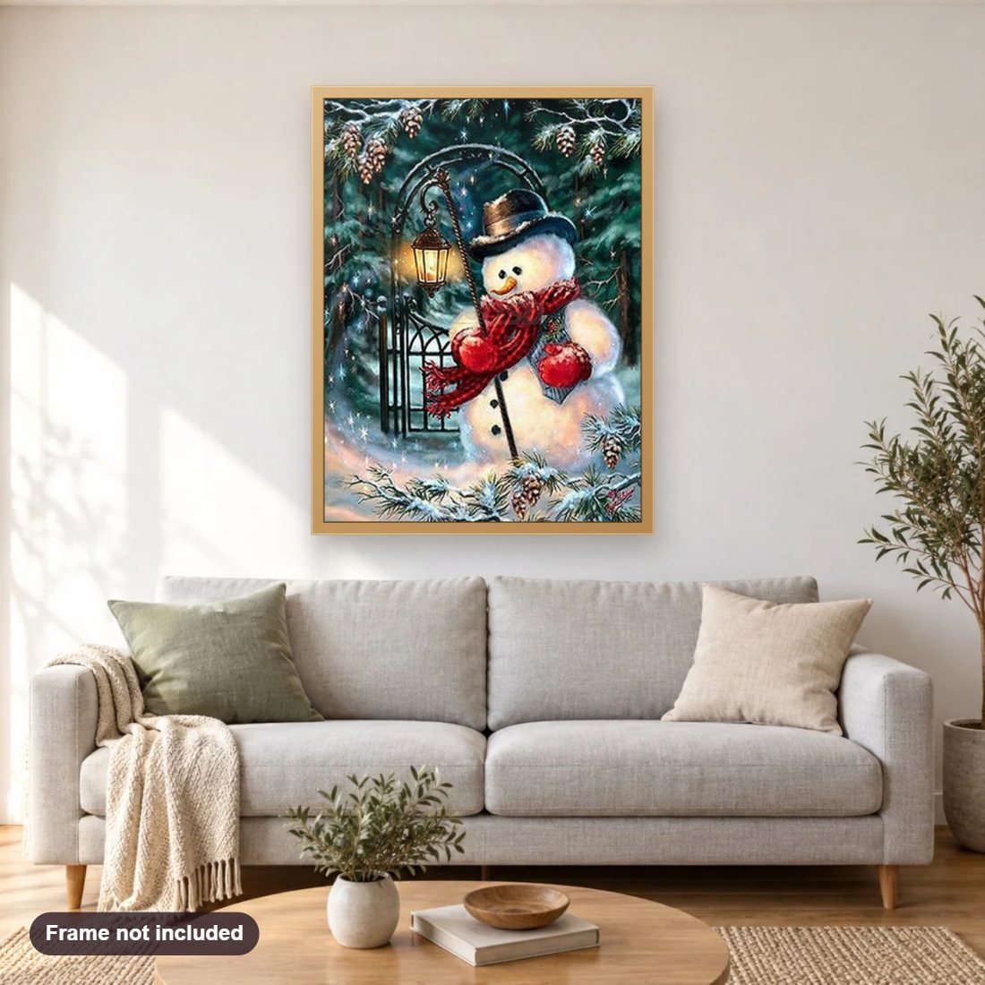 Sad Snowman with Lantern diamond painting shown framed on a living room wall above a sofa