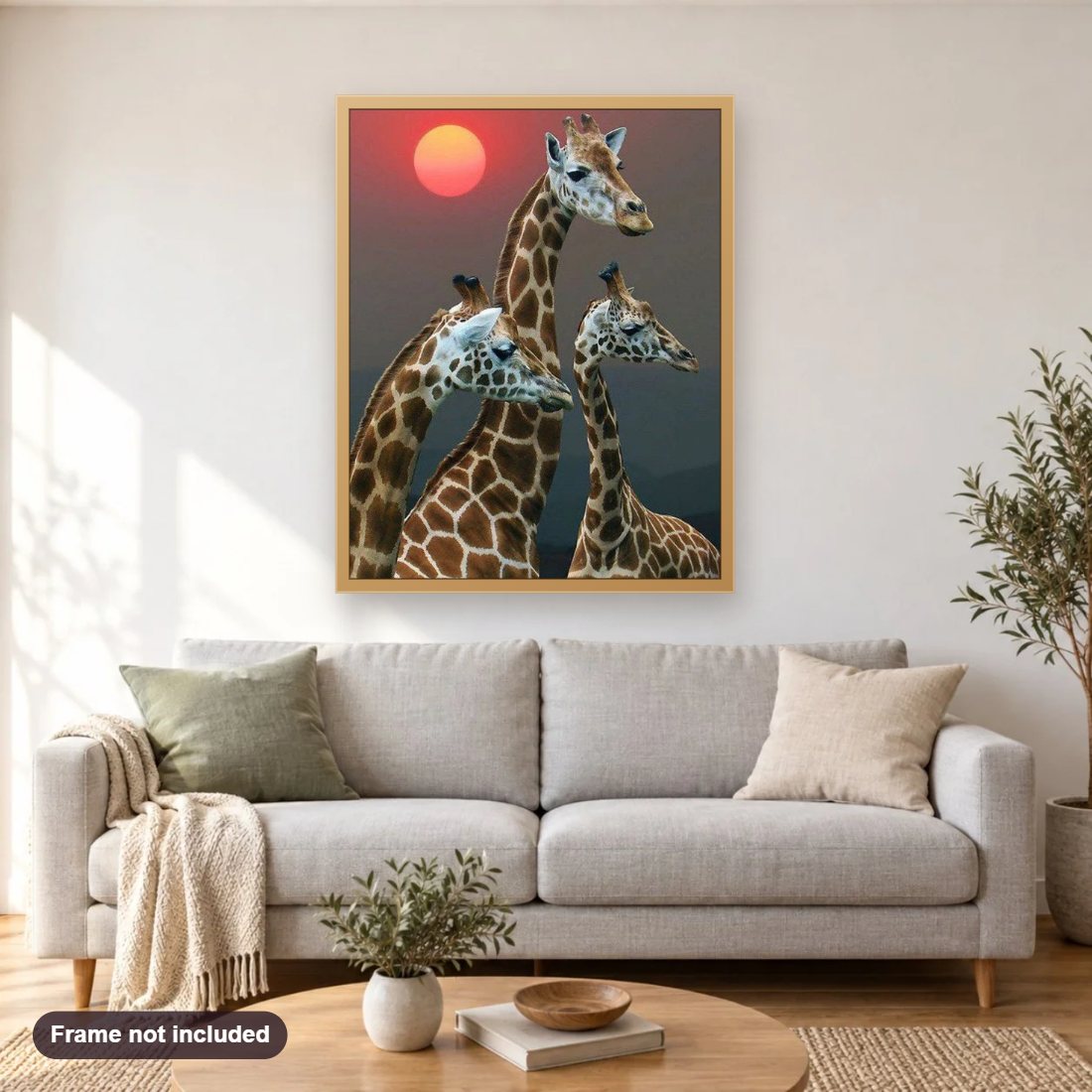 Setting Sun & Giraffe Family diamond painting shown framed on a living room wall above a sofa