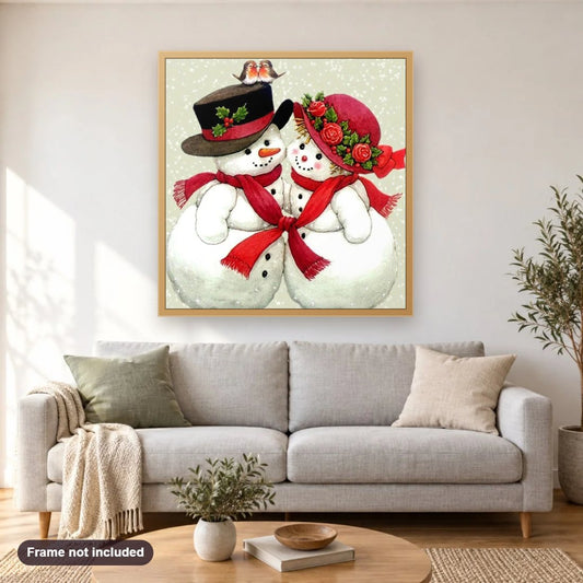 Snowman & Birds Pair diamond painting shown framed on a living room wall above a sofa