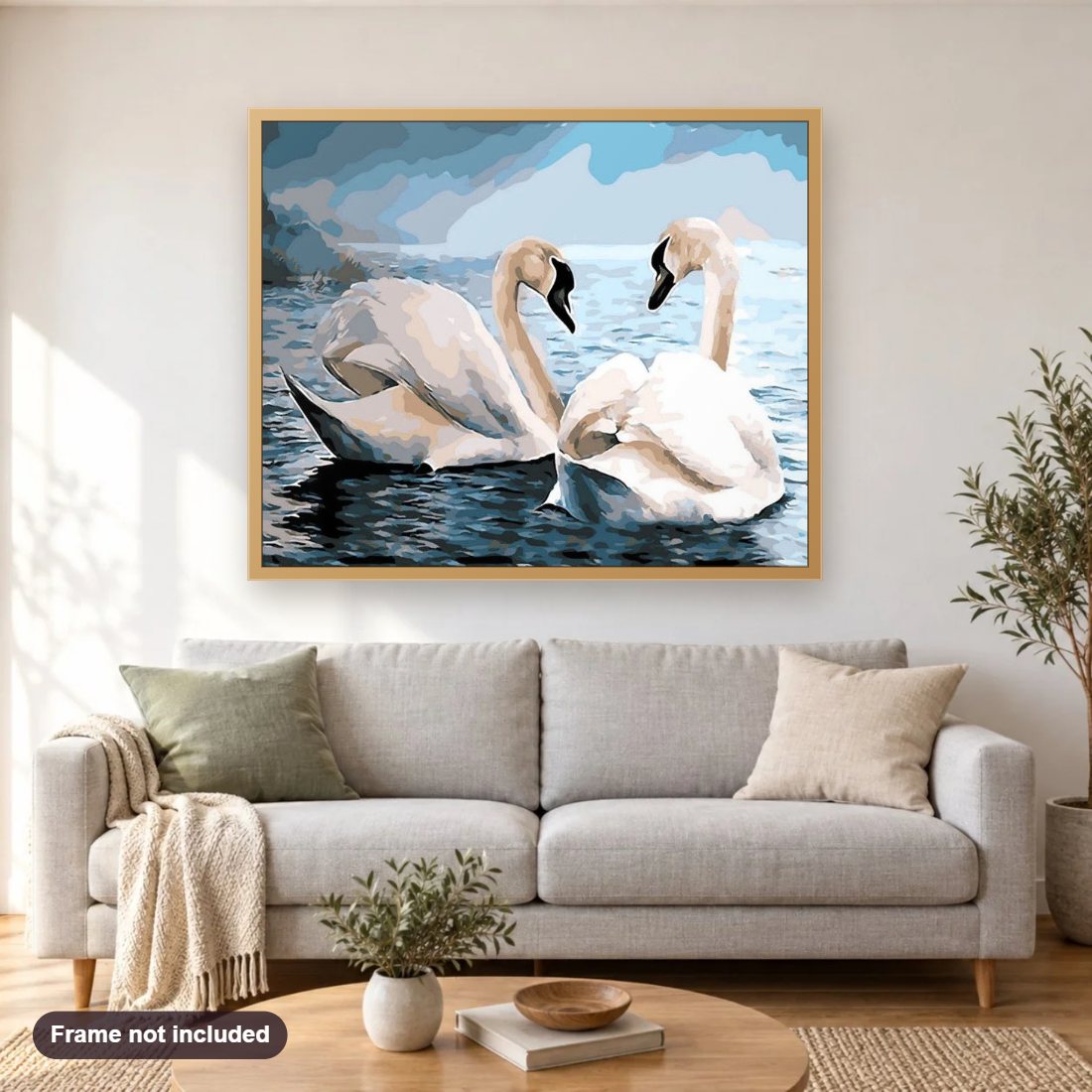 Swans Pair in Water diamond painting shown framed on a living room wall above a sofa
