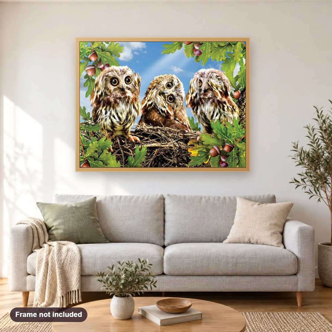 Three Owls on the Tree diamond painting shown framed on a living room wall above a sofa