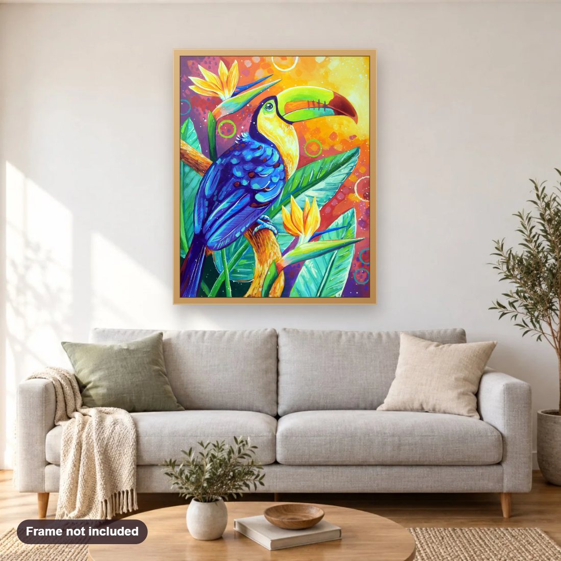 Toucan Among Birds of Paradise diamond painting shown framed on a living room wall above a sofa