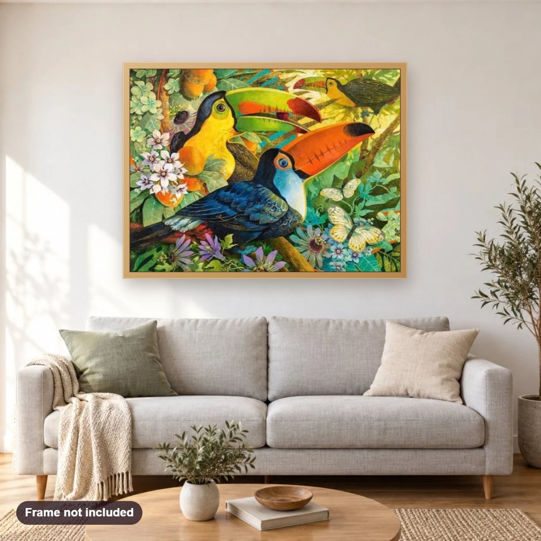 Toucans Sitting in Flowers diamond painting shown framed on a living room wall above a sofa