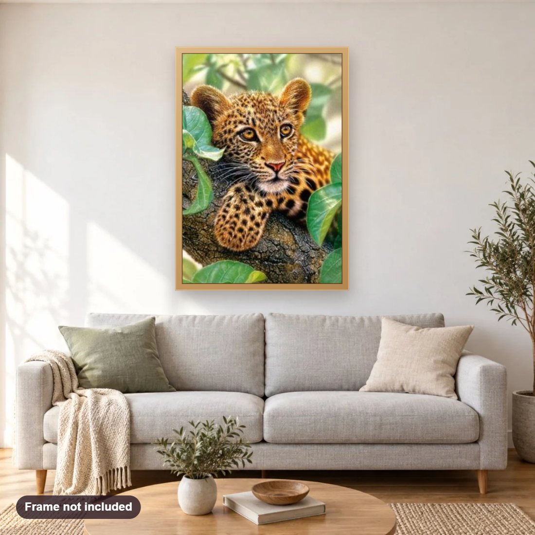 Tree Hugger Leopard Cub diamond painting shown framed on a living room wall above a sofa