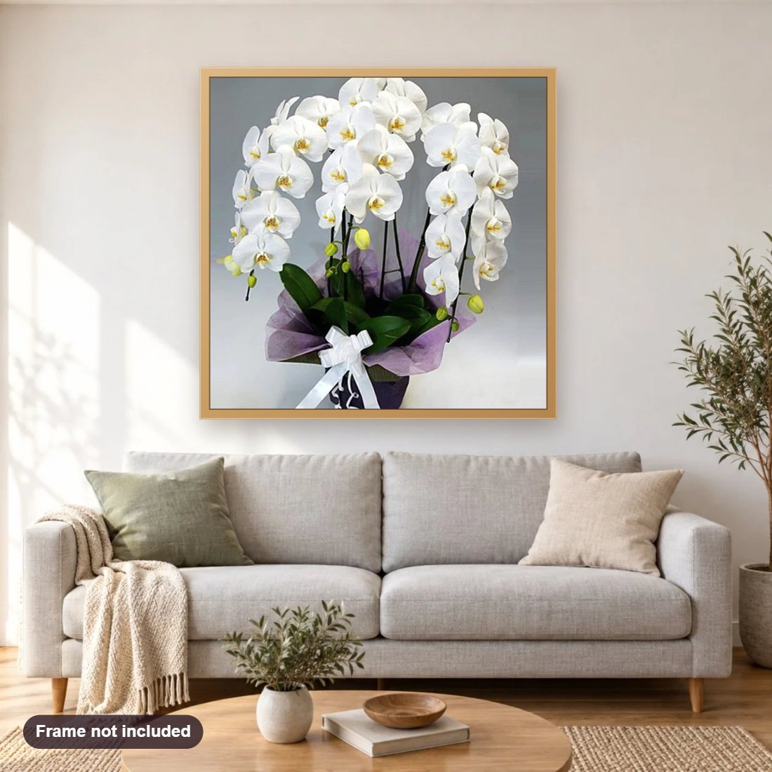 White Orchids diamond painting shown framed on a living room wall above a sofa